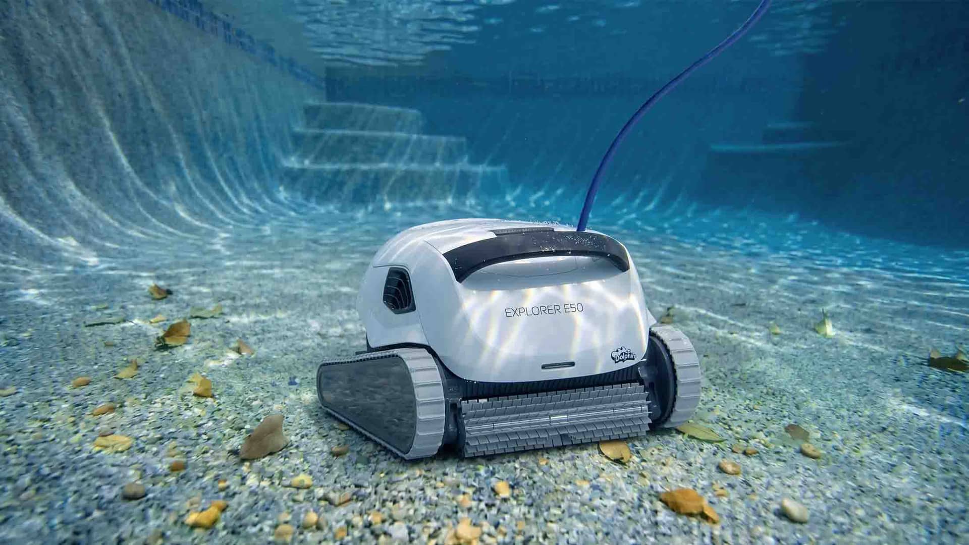 Dolphin Explorer E50 robotic pool cleaner on the floor of a backyard pool